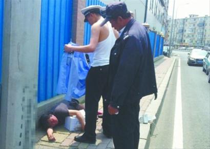 中年妇女因高温晕倒 交警脱警服为其遮阳