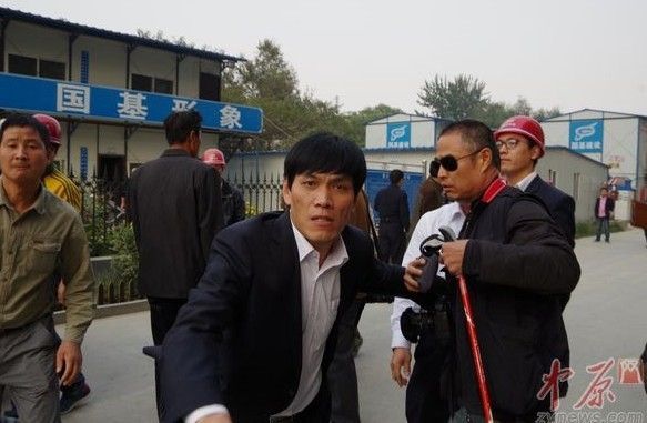工地上这名男子先抢大河报记者的相机，随后又扑向郑州晚报记者。中原网图