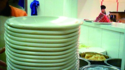 这些盘子被通过窗口递进码盘室直接使用 未经消毒 摄/法制晚报暗访组佴