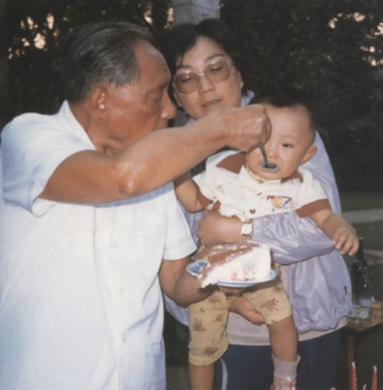 1986年8月22日，邓小平在北京家中喂孙子邓卓棣吃蛋糕。