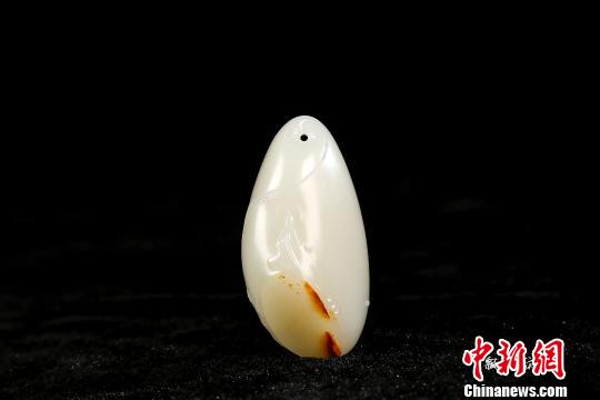 图为王一卜创作的新品“飘如浮云”佛像玉雕挂件，飘逸古朴，色彩清雅。　唐贵江 摄