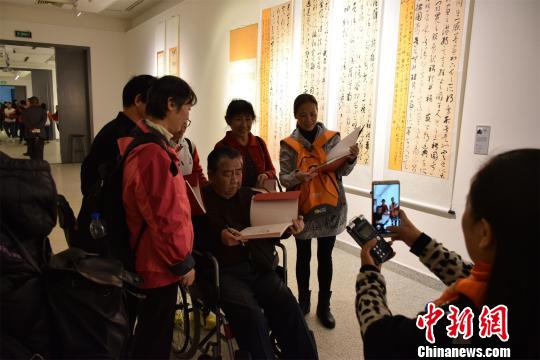 观众与残疾人艺术家合影并索要签名。　马芙蓉 摄