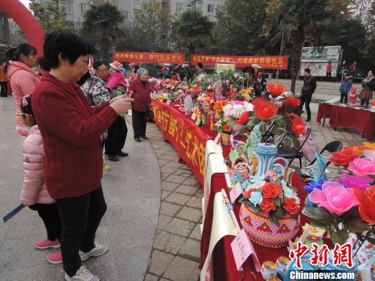郑州手工艺大赛展示的布艺、纸雕、面塑、剪纸的手工艺品色彩艳丽,造型别致,引来民众围观拍照。 韩章云 摄