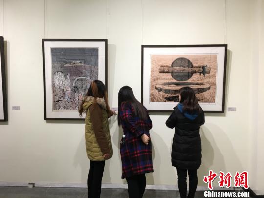 观众认真欣赏展出的版画作品。 高红超 摄