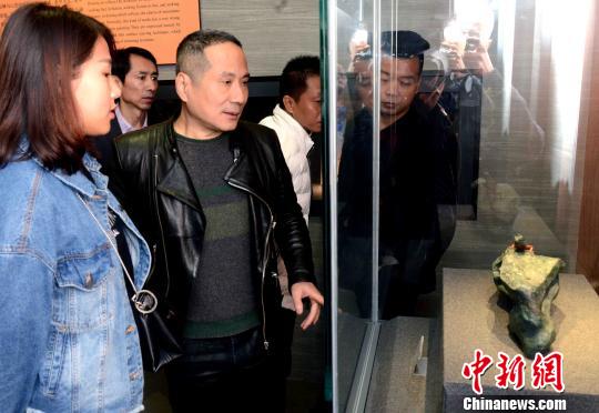 中国玉石雕艺术大师、福建省寿山非物质文化遗产传承人潘惊石(图中)向观众介绍自己作品的创作体会。　记者刘可耕 摄