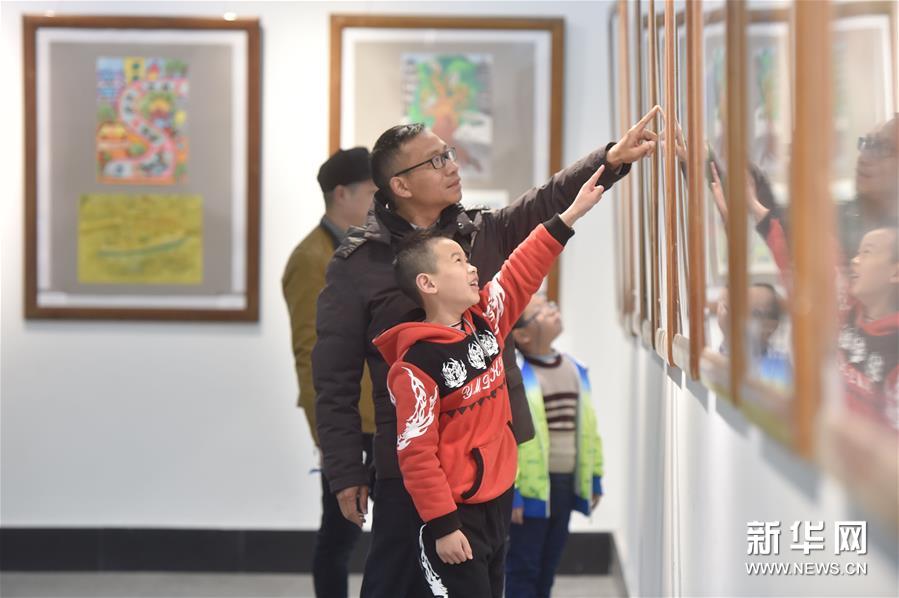 3月11日，福州市乌山小学二年级学生张常乐(前)和父亲一起参观中小学生绘画作品。新华社记者 宋为伟 摄
