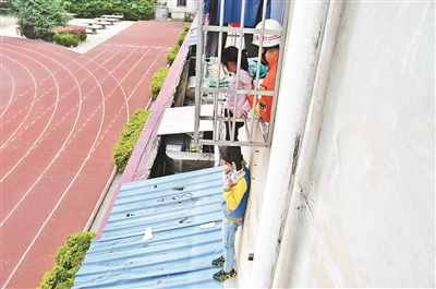 12岁男孩爬墙头托举被卡女童 救下女孩后悄然离去