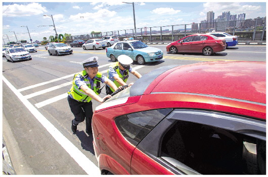 高温下的路面交警：冒着酷暑维护着大桥的通行秩序