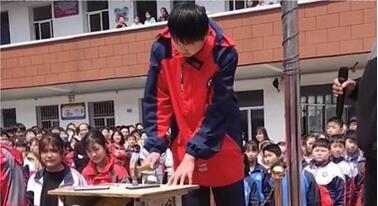  河南一学校组织学生当众集体砸手机：学生上升旗台拿起小锤子砸